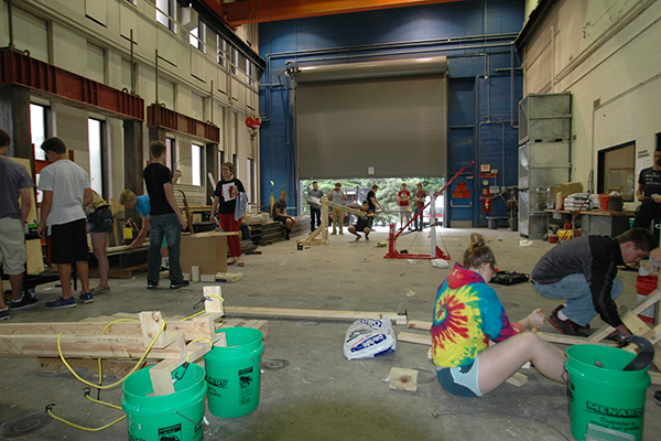 Teams of students prepare their tennis ball launchers in a high bay area of Scott Engineering Center.